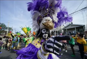  ?? Gerald Herbert/Associated Press ?? A member of the traditiona­l Mardi Gras group The Trams marches Tuesday during the Krewe of Zulu Parade on Mardi Gras Day in New Orleans.