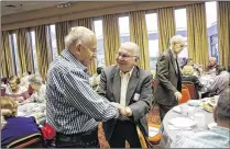  ?? YUTING JIANG / THE PALM BEACH POST ?? Pierre Chanover (right), a Holocaust survivor who was born in Paris, greets his friend, Max Markovitz, at the “Café Europa” event Thursday at Temple Torat Emet in Boynton Beach.