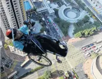  ?? PHOTO: REUTERS ?? Don’t look down . . . Lai Chiwai, a paraplegic climber, attempts to climb the 320m tall Nina Tower in Hong Kong yesterday.