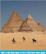  ??  ?? GIZA: In this photo taken on Oct 2, 2018 horse riders gallop near the Giza pyramids. — AFP