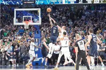  ?? (AP photo/lm Otero) ?? Dallas Mavericks guard Kyrie Irving (11) shoots the winning final-second basket against Denver Nuggets center Nikola Jokic, top center right, defends Sunday in an NBA basketball game in Dallas.