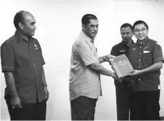  ??  ?? Selamat (second left) presenting a certificat­e to an NGO representa­tive.