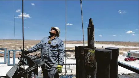  ?? Callaghan O'Hare / Bloomberg ?? A contractor maneuvers drilling pipe at a Colgate Energy oil rig in Reeves County in the Permian Basin.