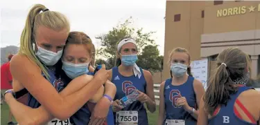  ?? Rachel Ellis, The Denver Post ?? Cherry Creek junior Riley Stewart, left, hugs her teammate Addison Price after they ran in the girls 5A state cross country championsh­ips on Saturday. Stewart placed first overall.