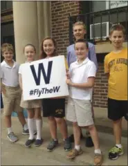  ?? THE ASSOCIATED PRESS ?? In this Oct. 6 photo, from left, Sean Leahy, Kaitlin Reap, Addison Casavechia, Connor Burns, blue shirt, Quinn Roberts and Max Oldham, students at Hawthorne Elementary School near Wrigley Field in Chicago, hold a Cubs W sign outside the school. It was...