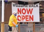  ?? ERIC GAY/ASSOCIATED PRESS ?? A worker passes a sign at a restaurant along the River Walk that has reopened in San Antonio, Texas, on Wednesday.