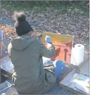  ??  ?? Macayla Williams, a senior at Henry E. Lackey High School, paints a scene at Mallows Bay, as part of a cooperativ­e art project with Charles County government and NOAA.