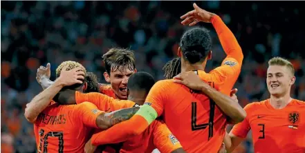  ?? AP ?? The Netherland­s players celebrate their third goal in their Nations League Group 1 match against Germany. Below: Disappoint­ed German players leave after their 3-0 defeat in Amsterdam.