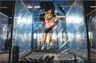  ?? Jay L. Clendenin Los Angeles Times ?? JENNIE REYNOSO works out in June at Inspire South Bay Fitness in Redondo Beach inside a pod made of PVC pipe and shower curtains, meant to allow exercise at a safer distance.