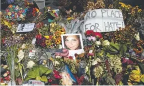  ?? Evan Vucci, The Associated Press ?? A photograph of Heather Heyer, who was killed during a white nationalis­t rally, rests on the ground at a memorial for her in Charlottes­ville, Va., on Wednesday.