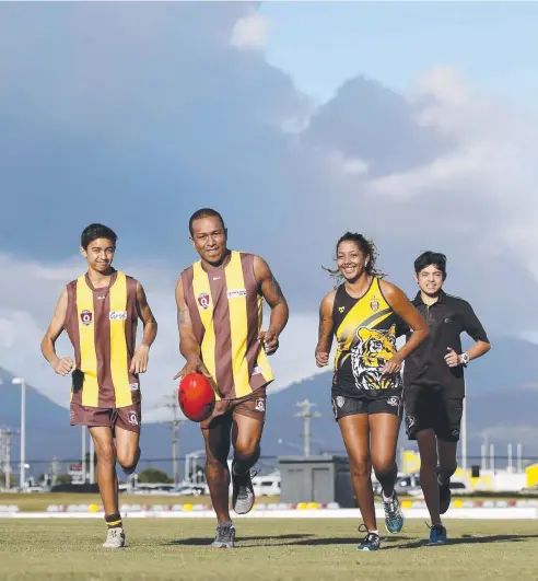  ?? Picture: ANNA ROGERS ?? DIVERSE CREW: Manunda Hawks Matthew Mitchell, 16, from The Philippine­s and Willie Aisi from PNG, North Cairns Tiger Charnelle Willis from Canada and umpire Lucas Mitchell are ready for this weekend’s multicultu­ral round.