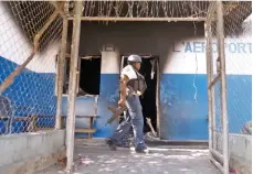  ?? AP ?? Un policía camina junto a una comisaría quemada que fue incendiada por pandillero­s en Puerto Príncipe, el martes 5 de marzo de 2024.