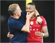  ?? (AFP) ?? Bayern Munich coach Hans-Dieter Flick (left) congratula­tes his player David Alaba after the German Cup final against Bayer 04 Leverkusen in Berlin, Germany, on Saturday.