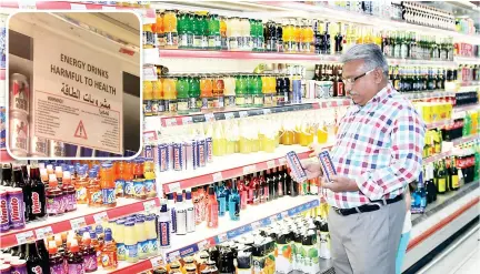  ??  ?? A man looks at an energy drink at a supermarke­t in Dammam. (Inset) ‘This product does not have any health benefits’ — new health warning of energy-drinks shelves as excise tax hits market. (AN photos by Imran Haider & Lulwa Shalhoub)