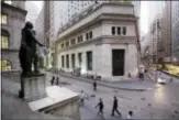  ?? MARK LENNIHAN — THE ASSOCIATED PRESS FILE ?? People walk to work on Wall Street beneath a statue of George Washington, in New York. The market’s biggest winners this year, technology and health care, powered U.S. stock indexes to more alltime highs on Tuesday.