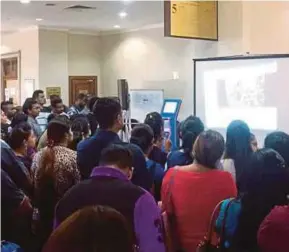  ??  ?? Family members of the accused gathering at the Kuala Lumpur High Court entrance to watch a live broadcast of the court proceeding­s yesterday.