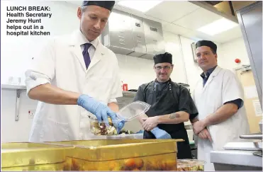  ??  ?? LUNCH BREAK: Health Secretary Jeremy Hunt helps out in a hospital kitchen