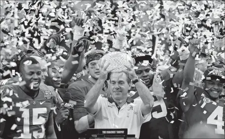  ?? GERALD HERBERT/AP FILE PHOTO ?? Alabama head coach Nick Saban celebrates with his team after winning the BCS National Championsh­ip against LSU on Jan. 9, 2012, in New Orleans. Saban, the stern coach who won seven national championsh­ips and turned Alabama back into a national powerhouse that included six of those titles in just 17 seasons, retired Wednesday, leaving giant shoes to fill.