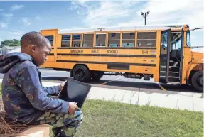  ?? MICKEY WELSH/USA TODAY NETWORK ?? Brayson Lockwood, a student at E.D. Nixon Elementary School in Montgomery, Ala., logs onto the internet signal from a Montgomery Public School bus parked at a YMCA last spring. The internet buses help students access remote classes even if they don't have reliable internet at home.