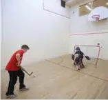  ??  ?? Nathaniel practises his shot, with brother Benjamin in goal, in their building’s squash court.