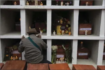  ??  ?? In this Nov. 30 photo, an Ixil Maya man prays next to the niches where 172 civil war victims were placed, at the cemetery in Santa Avelina, Guatemala. Since the exhumation­s in Santa Avelina began in 2014, experts have identified 108 of the victims...