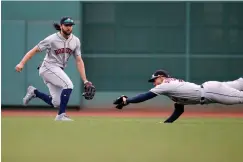  ?? Associated Press ?? ■ Houston Astros' George Springer, right, makes the catch in front of Jake Marisnick on the line out by Boston Red Sox's Mitch Moreland during the first inning of a baseball game Saturday in Boston.