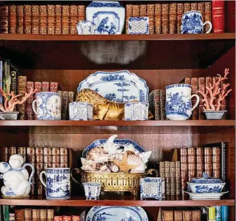  ?? Rizzoli / Stacey Bewkes ?? In a dining room, a bookcase is styled like a cabinet of curiositie­s, with gilded lions, shells, gilt bronze ormolu, coral and 18th-century porcelain.