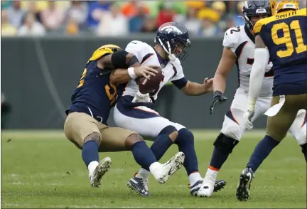  ?? MATT LUDTKE — THE ASSOCIATED PRESS ?? Denver Broncos quarterbac­k Joe Flacco, right, is sacked by Green Bay Packers linebacker Rashan Gary on Sunday. This is the kind of defensive pressure the Eagles can expect from the 3-0Packers Thursday night at Lambeau Field.