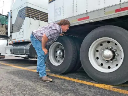  ?? AP PHOTO/TOM SAMPSON ?? Hay farmer and truck driver Terry Button looks over his trailer during a stop in Opal, Va.