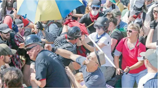  ?? AP file ?? White nationalis­t demonstrat­ors clash with counter-demonstrat­ors at the entrance to Lee Park in Charlottes­ville, Virginia. —