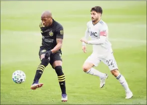  ?? Emilee Chinn / Getty Images ?? The Crew’s Darlington Nagbe controls the ball against the Revolution’s Carles Gil in the first half during the Eastern Conference Final of the MLS Cup Playoffs at MAPFRE Stadium on Sunday in Columbus, Ohio. Columbus won 1-0.