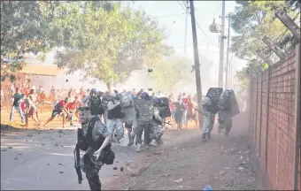  ??  ?? La enardecida turba de “sintechos” hizo retroceder en un momento al pelotón policial y se desató una batalla campal en el Kilómetro 10 “Monday” de Ciudad del Este.