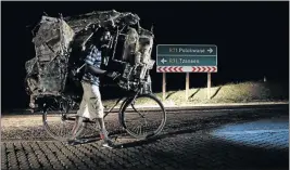  ??  ?? TIRED BUT MOVING: Richard Ngobeni pushes his ‘motorbike’ on the R71 road as night falls