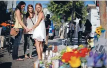  ?? Photos: REUTERS ?? Students, from left, Amber McCoy, 20, Ava Ames, 23, and Jenn Bowman, 21, pray in front of a makeshift memorial for university student Christophe­r Michael-Martinez, 20, outside a deli that was one of nine crime scenes after series of killings by Elliot...