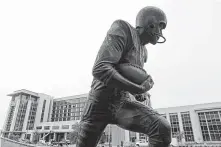  ?? Melissa Phillip / Houston Chronicle ?? A statue honoring John David Crow, winner of the 1957 Heisman Trophy is across the street from the hotel.