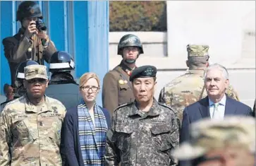  ?? Lee Jin-man Pool Photo ?? U.S. SECRETARY OF STATE REX TILLERSON, right, stands next to South Korean military commander Gen. Leem Ho-young at the Demilitari­zed Zone as North Korean soldiers look on in the background.