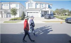  ?? REUTERS ?? A couple walks in front of the house where former Brazilian President Jair Bolsonaro is staying, in Kissimmee, Florida.