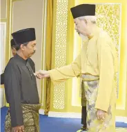  ??  ?? BUSMIN (kiri) ketika dikurniaka­n pingat BSK daripada Tun Juhar.