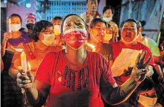  ?? GETTY IMAGES ?? A protester makes a three-finger salute during a candleligh­t protest in Yangon on Friday.