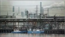  ?? AP PHOTO/MIKE DERER ?? In this 1990 file photo, two clean harbor cleanup boats work in the Arthur Kill waterway in front of the Exxon oil refinery in Linden, N.J. As much as 546,000 gallons of No. 2 heating oil spilled from an Exxon underwater pipeline, temporaril­y closing...