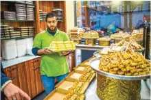  ??  ?? An employee is seen working in the ‘Konditorei Damaskus’ pastry shop in the Neukoeln neighbourh­ood of Berlin.