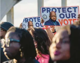  ?? BRANDON BELL/GETTY ?? People with posters featuring late U.S. Rep John Lewis march on March 6 across the Edmund Pettus Bridge in Selma, Ala.