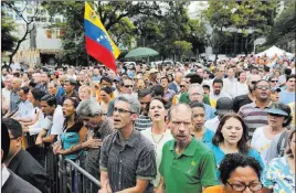  ?? Fernando Llano ?? The Associated Press People sing Venezuela’s national anthem Friday at a swearing-in ceremony for newly named Supreme Court justices in Caracas, Venezuela. The naming of the new justices is part of the opposition’s plan to resist President Nicolas...