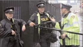  ?? The Canadian Press ?? Police officers armed with heavy automatic weapons stand guard a blocked street leading to Parliament Hill in preparatio­n for Canada Day in Ottawa on Friday.