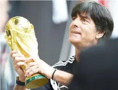  ??  ?? File photo of Germany head coach Joachim Loew holding the World Cup trophy during a public training session in Duesseldor­f, western Germany. — AFP photo