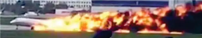  ??  ?? Terror flight: The Russian Sukhoi Superjet-100 hits the runway at Moscow trailing flames and black smoke. Below, passengers flee the blaze on emergency slides