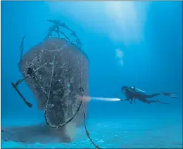  ?? ?? A scuba diver inspects a sunken shipwreck off the Maldives