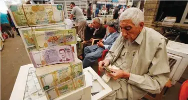  ?? Reuters ?? ↑
A man counts money at a Stock Exchange in Erbil, Iraq.