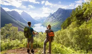  ?? ?? Two hikers admire the view of a valley in Norway.