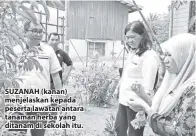  ??  ?? SUZANAH (kanan) menjelaska­n kepada peserta lawatan antara tanaman herba yang ditanam di sekolah itu.